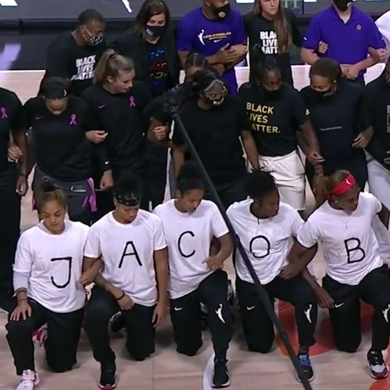A women's basketball team wearing shirts that say black lives matter and Jacob Blake